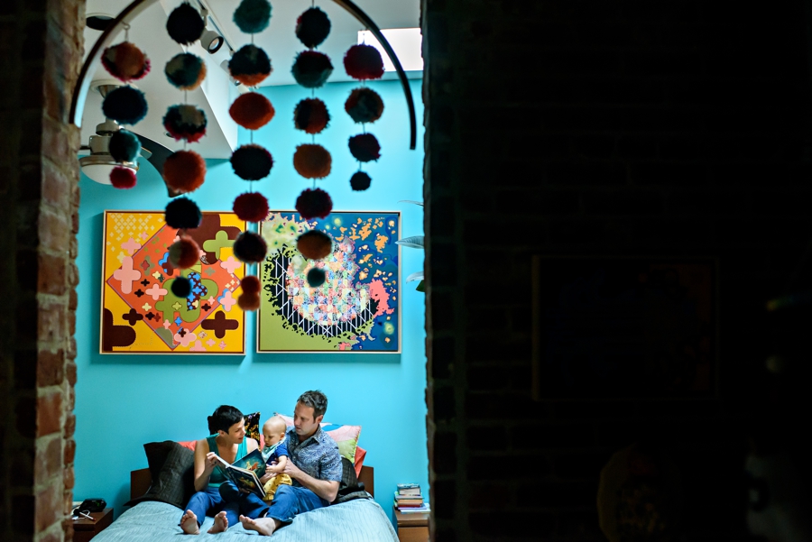A mother and father reading to their baby in the bed in philadelphia.